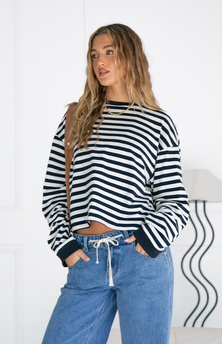 Front view of a navy and white striped long sleeve top with a crew neck, relaxed fit, and cropped hem