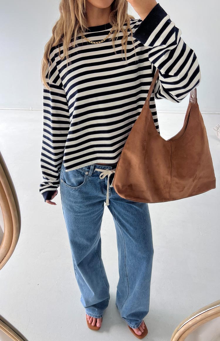 Full length view of a navy and white striped long sleeve top with a crew neck and cropped hem