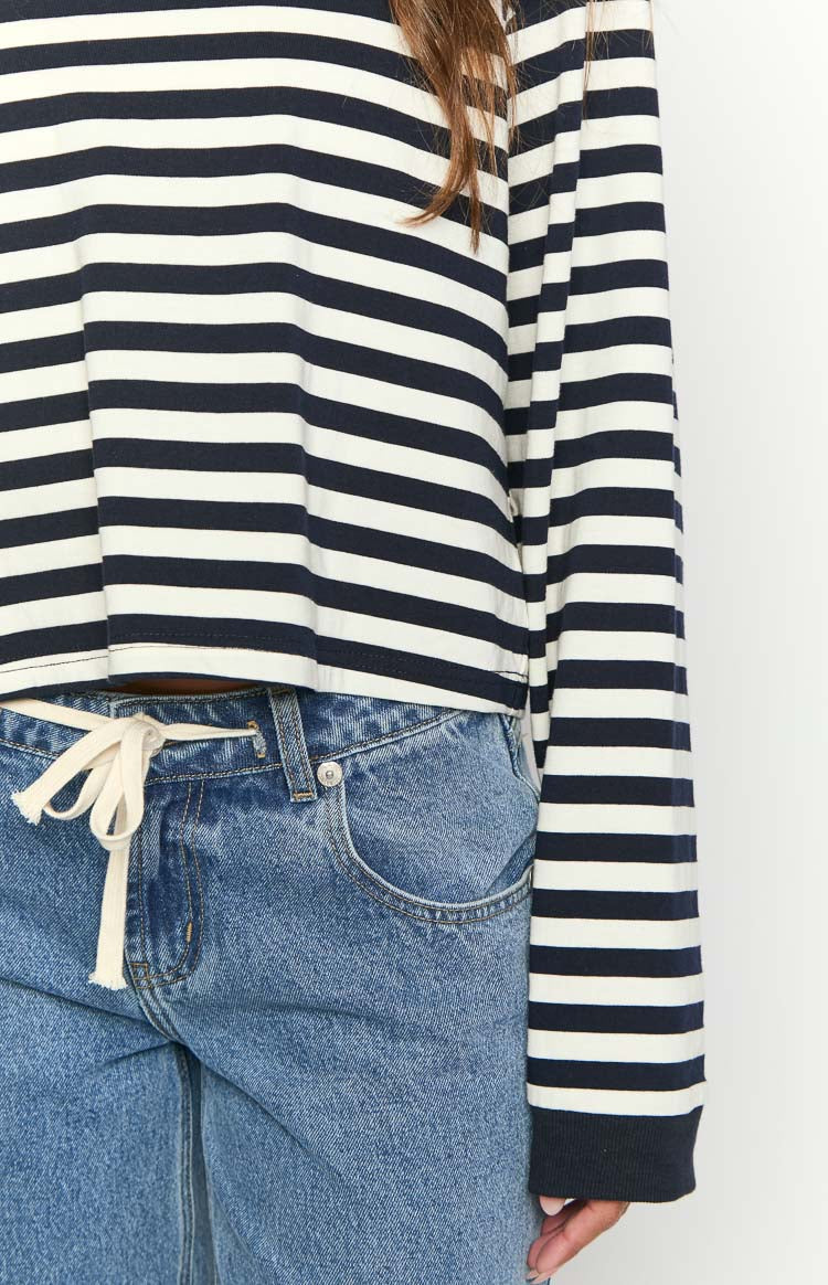 Detail shot of the navy and white striped long sleeve top's cropped hem and ribbed sleeve cuffs