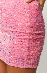 Close-up of the ruched side seam and iridescent sequins on a pink mini dress