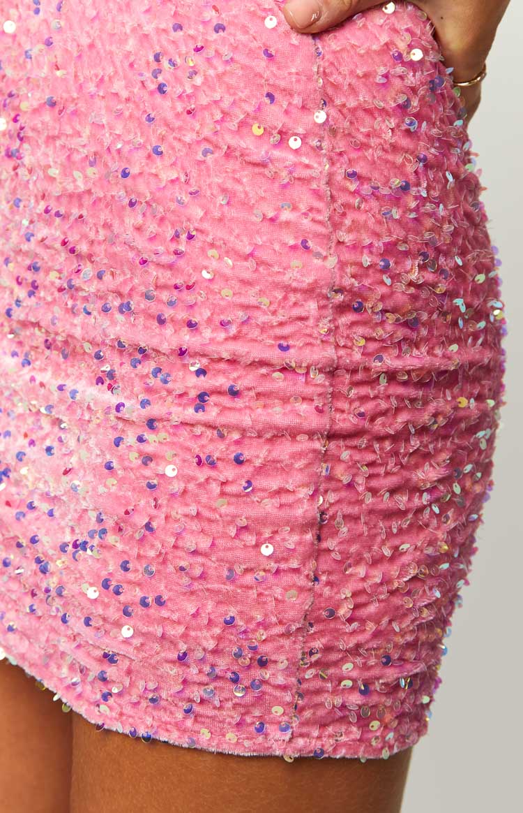 Close-up of the ruched side seam and iridescent sequins on a pink mini dress