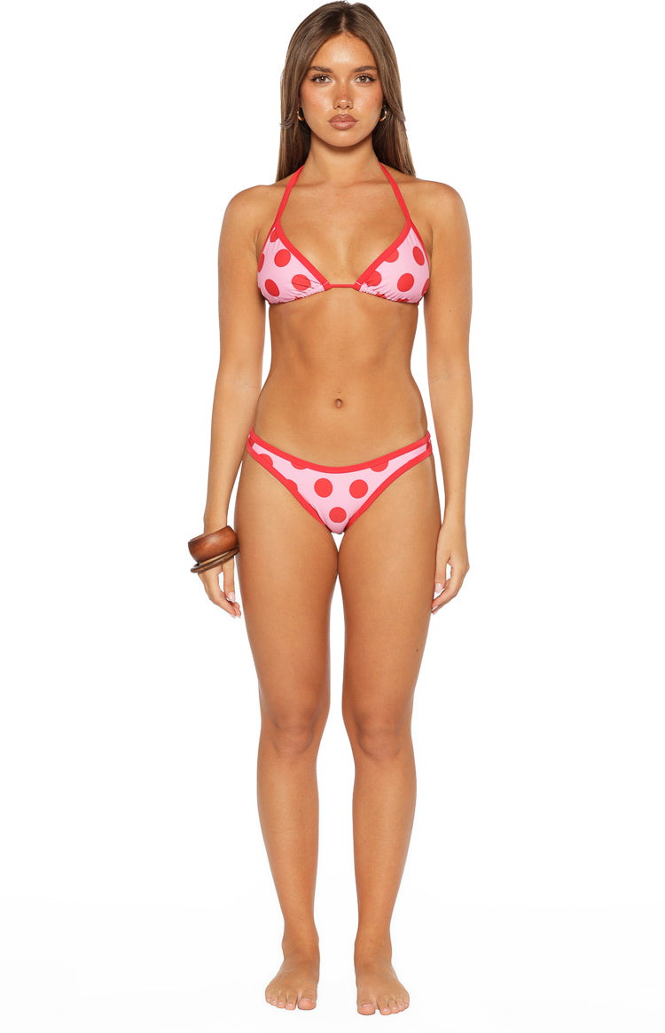 Pink and red polka dot triangle bikini top with red contrast binding, shown with matching bottoms