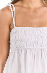 Close-up of the white ruched bodice and delicate tie straps on a white top