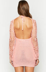 Rear view of a pink crochet mini dress with a low scoop back, halter neck tie, and long floral crochet sleeves