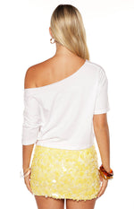 Back view of a fitted yellow mini skirt covered in large, round, flat sequins
