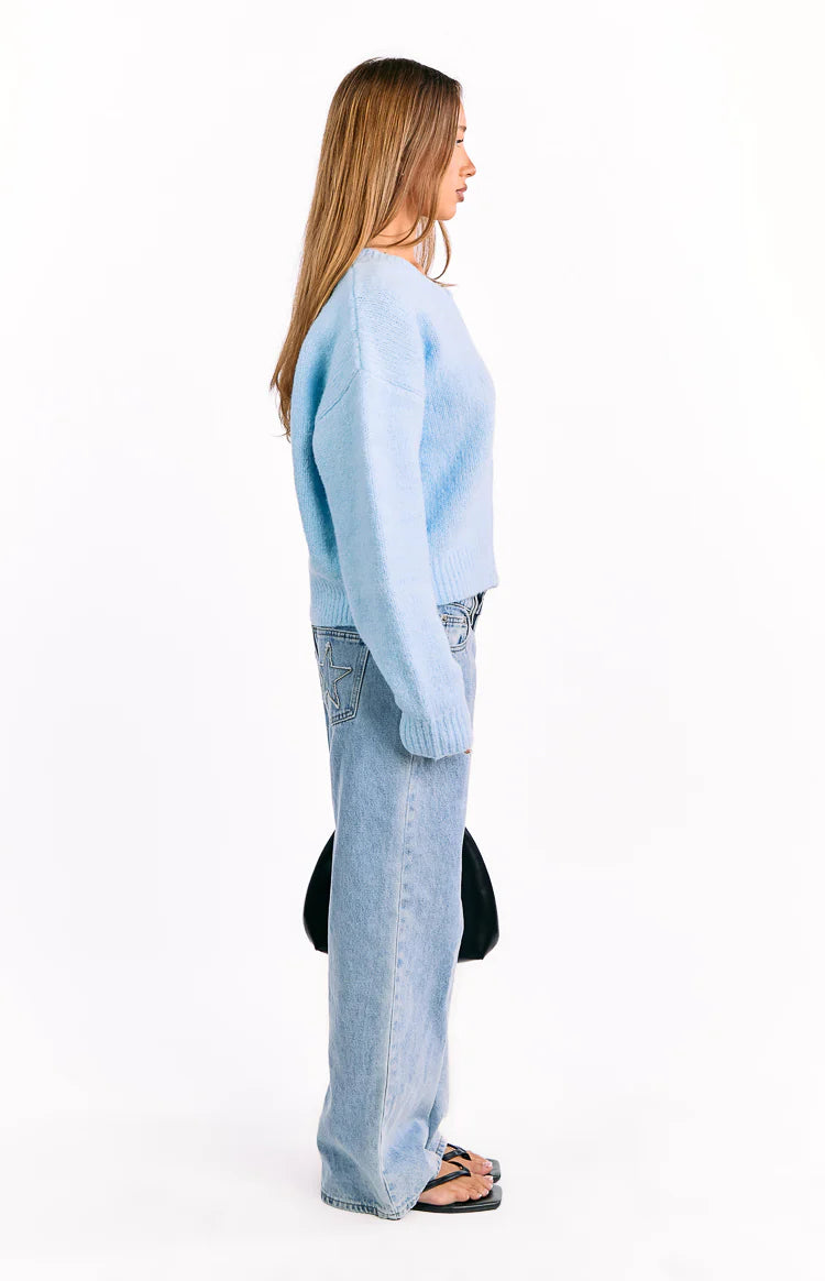 Side view of a light blue knit cardigan with long relaxed sleeves and a ribbed hem, casual