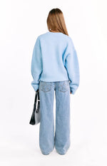 Front view of a light blue fuzzy knit cardigan with a full front zipper and ribbed cuffs