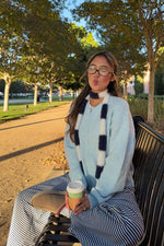 Light blue fuzzy knit cardigan with a relaxed fit and long sleeves, showing the partial zip neckline