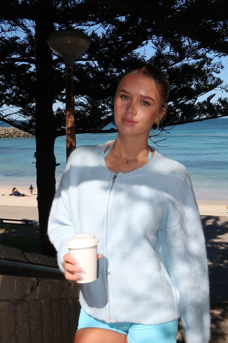 Light blue fuzzy knit cardigan with a round neck, long sleeves, and full-length zip