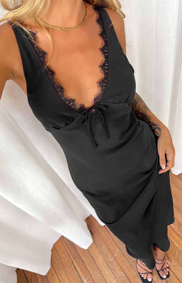 Side view of a black maxi dress with thin adjustable spaghetti straps and a low back