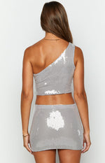 Rear view of a silver sequin one-shoulder crop top with an asymmetrical neckline