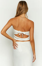 Rear view of a white satin strapless crop top with a back tie closure forming a bow and a cutout detail