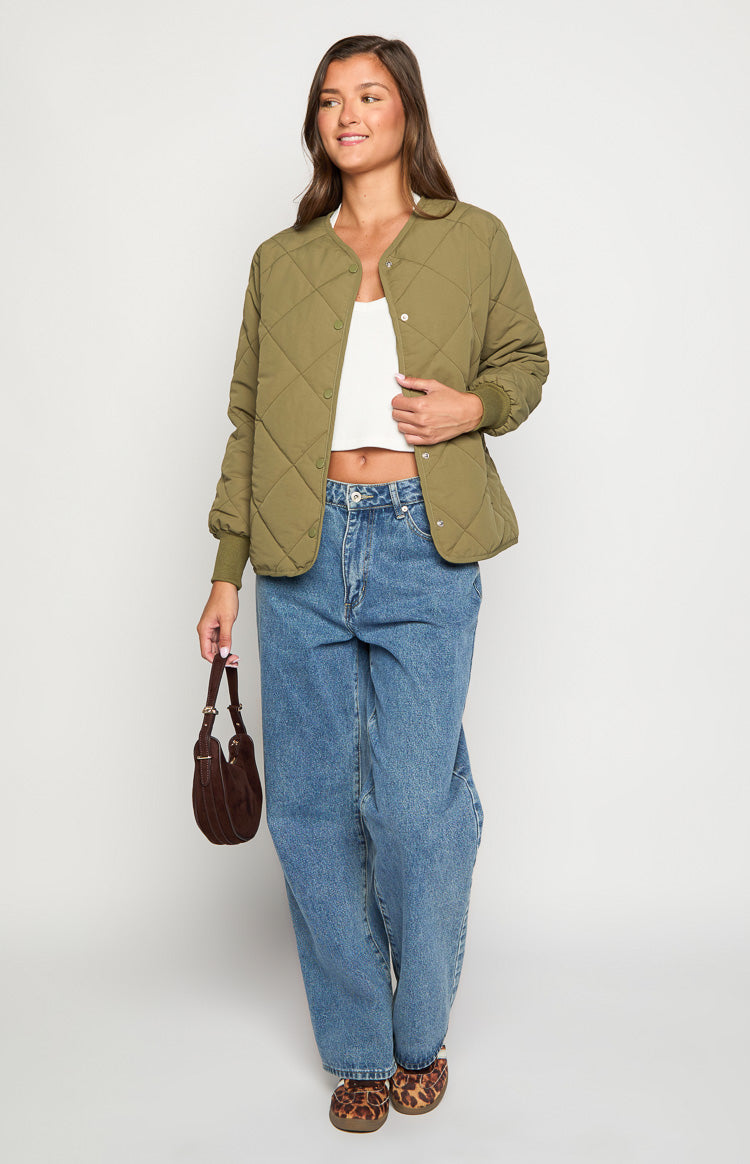 Khaki quilted bomber jacket worn open showing the round neckline and snap button front