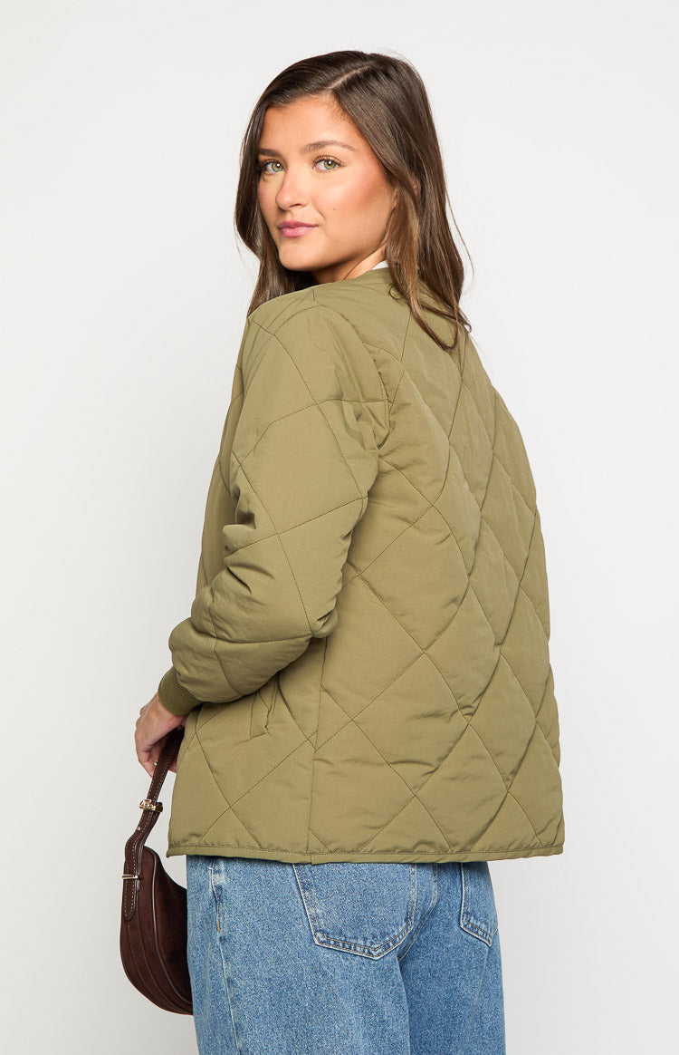 Rear-side view of a khaki quilted bomber jacket showing the diamond pattern and ribbed cuff