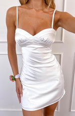 Close-up of the white satin mini dress showing the sweetheart neckline with criss-cross bust detail and thin spaghetti straps