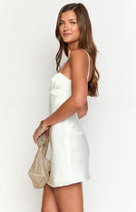 Side view of a white satin mini dress with thin spaghetti straps and a gathered bust detail