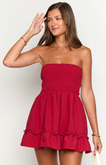 Front view of a red strapless dress with a shirred bodice and a tiered ruffled hemline