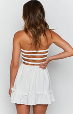 White strapless mini dress with four horizontal elasticated back bands and a ruffled hem