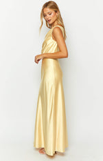 Side view of a yellow satin sleeveless maxi dress with a cowl neck and flowy skirt