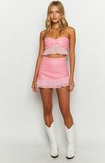 Pink fitted mini skirt with a smooth main body and a sheer ruffled organza hem