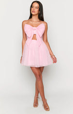 Front view of a light pink strapless mini dress with a large bow detail on the bust and a cutout waist