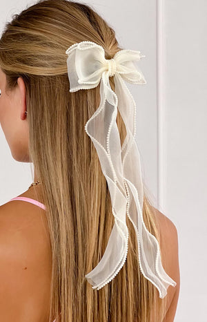 girl wearing a cream hair bow with pearl details