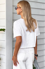 Rear view of a white cropped boxy tee with short sleeves and a straight hemline