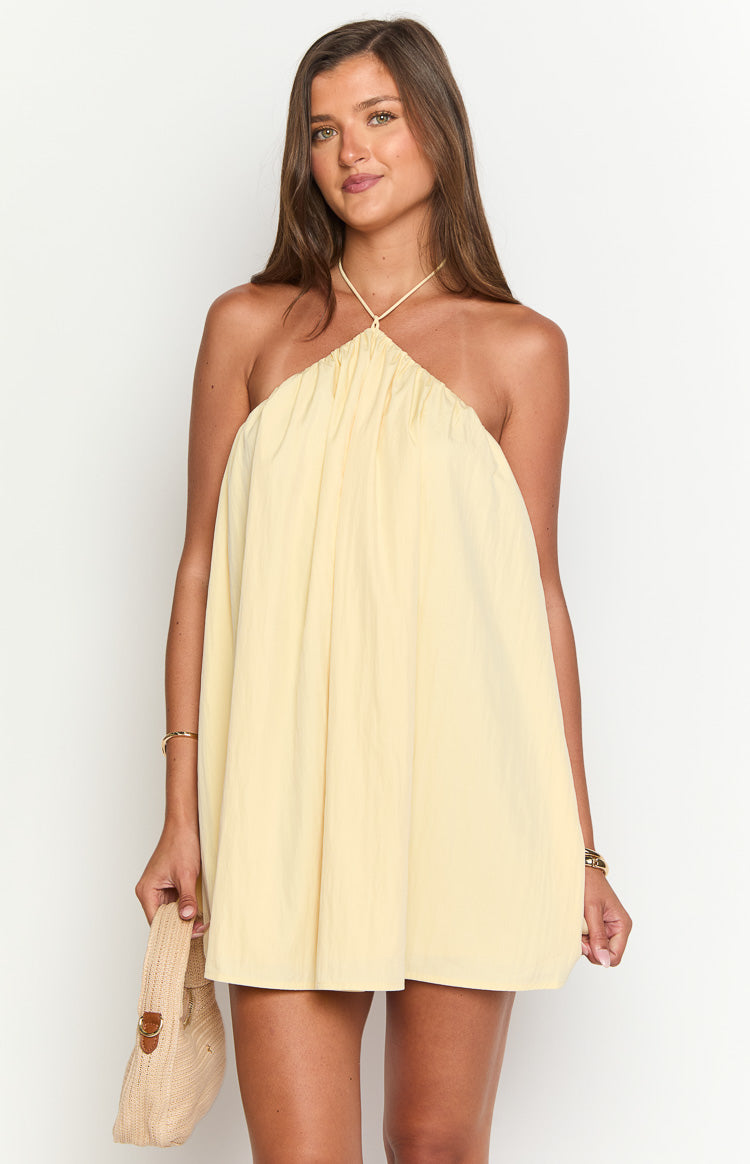 Yellow mini dress with a gathered halter neckline and thin tie straps, featuring a loose, voluminous silhouette