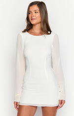 Close-up front view of a white mini dress with a round neck, fitted bodice, and sheer long sleeves