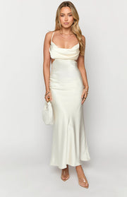 Cream satin maxi dress featuring a cowl neckline, delicate spaghetti straps, and prominent side cutouts