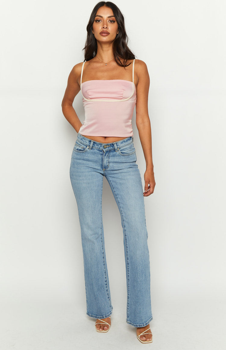 Side view of a pink satin cropped top with thin straps and white trim detail