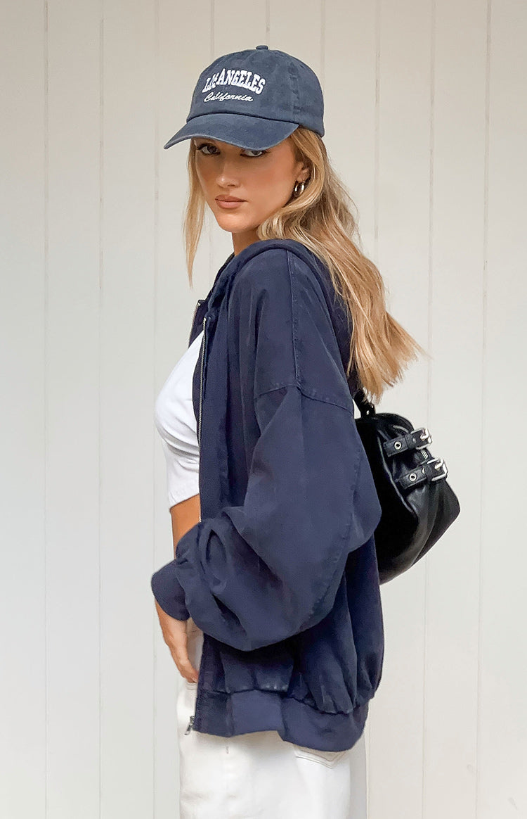 Side view of a washed navy oversized hooded jacket with a front zipper and elasticated cuffs