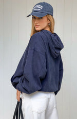 Rear-side view of a washed navy oversized hooded jacket with dropped shoulders and voluminous sleeves