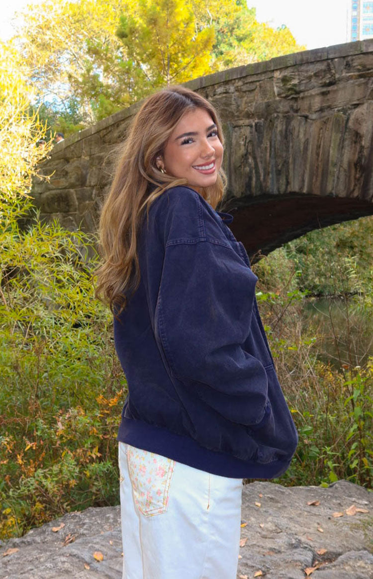Side view of a washed navy oversized hooded jacket with long sleeves and an elasticated hem