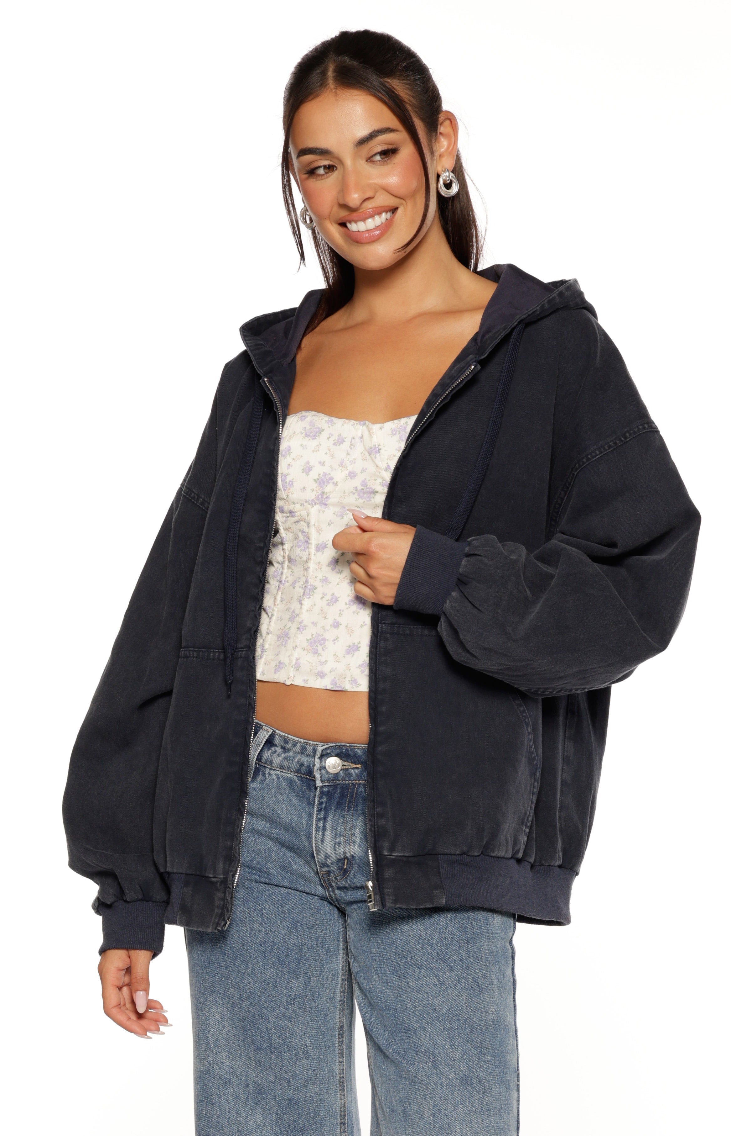 Close-up of a washed navy oversized hooded jacket with a partially open zipper and ribbed cuffs