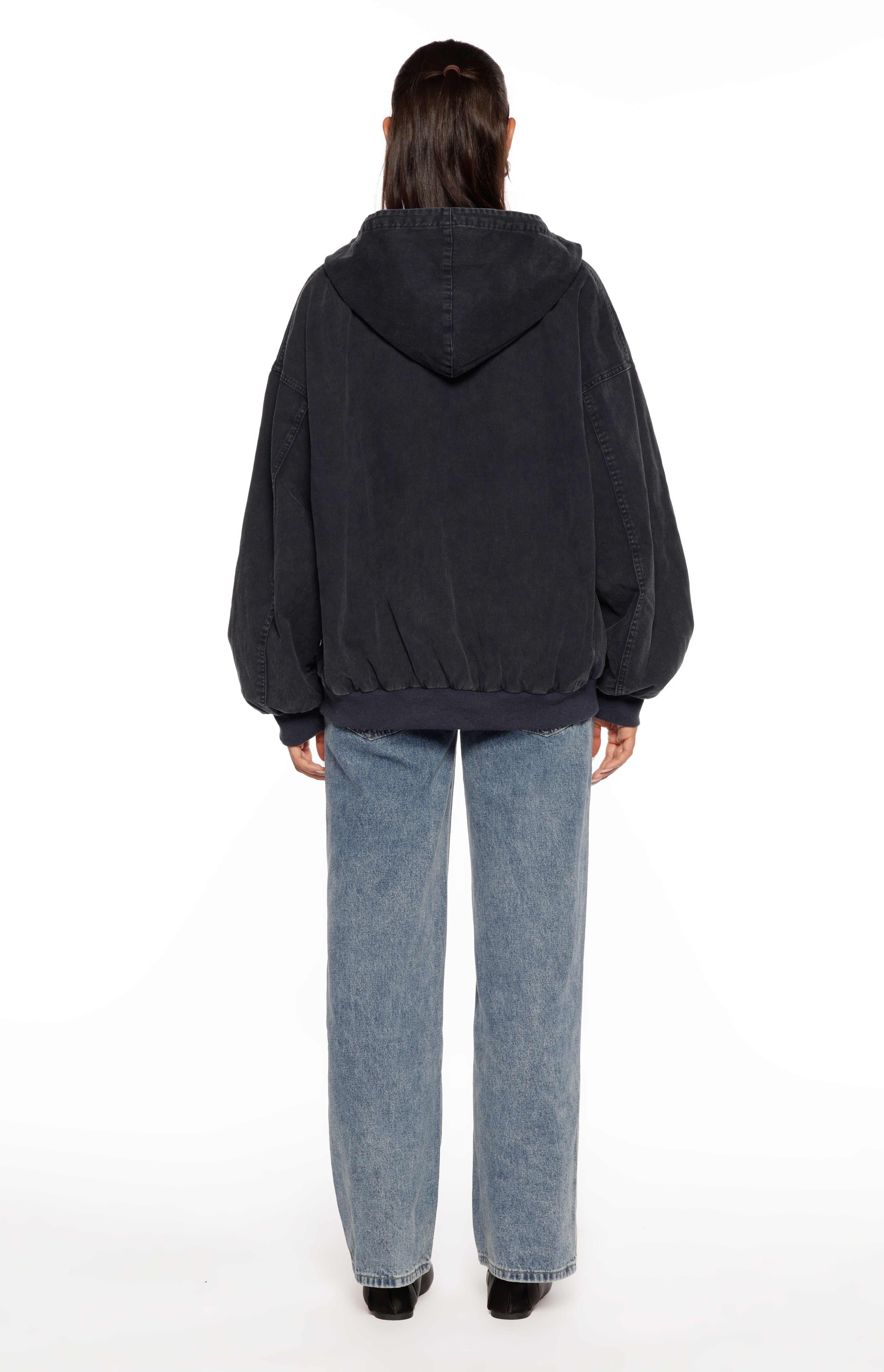 Rear view of a washed navy oversized hooded jacket with an elasticated hem and cuffs, showing seam details