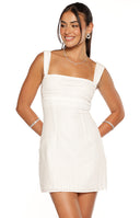 Close-up of the white mini dress with a square neckline, textured fabric, and lace insert at the midriff