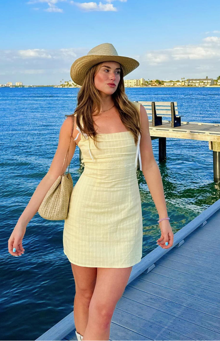Rear view of a yellow striped mini dress with a tie-back detail and waist cutouts