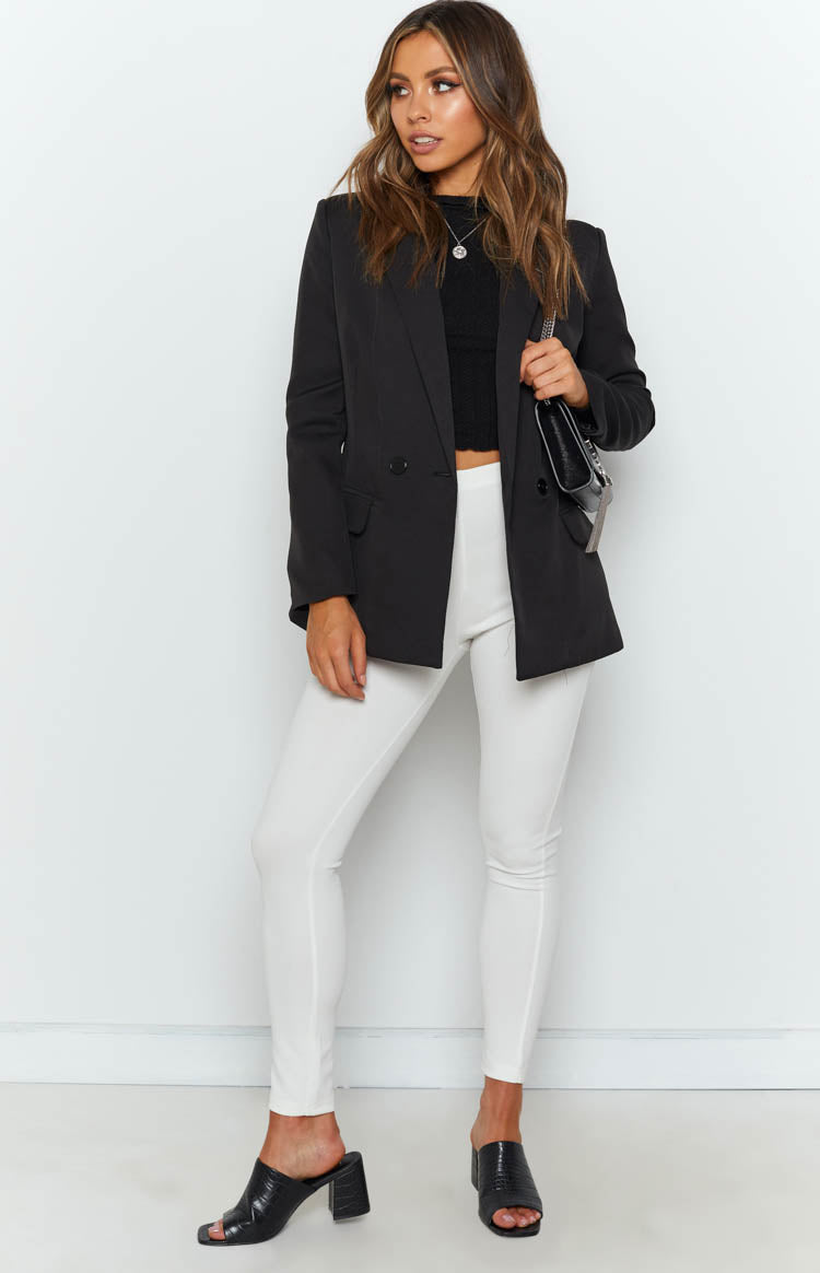 Black double-breasted blazer with notched lapels, long sleeves, and a relaxed fit