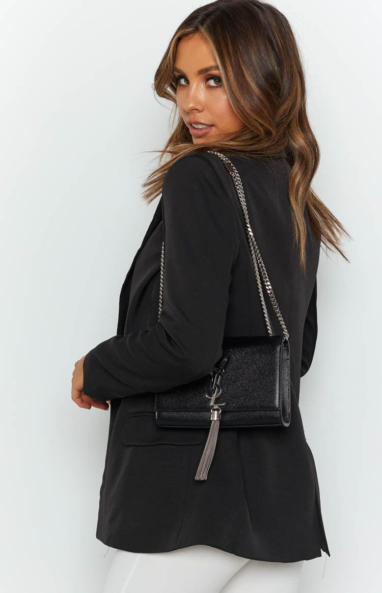 Smooth black long sleeve blazer with a relaxed fit and subtle side hem slits