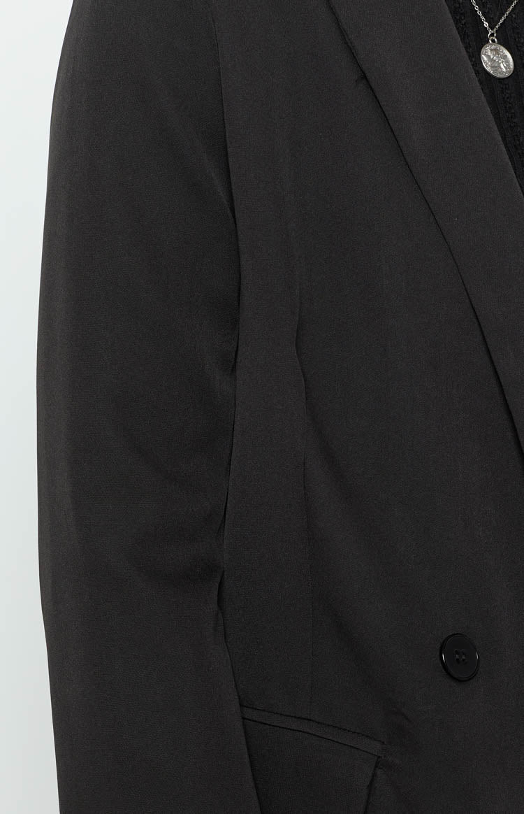 Smooth black blazer with a single round button and a pointed lapel