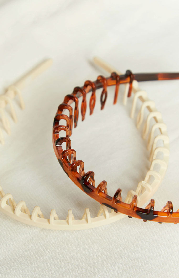 Cream plastic headband with a full row of small, rounded teeth along the inner edge