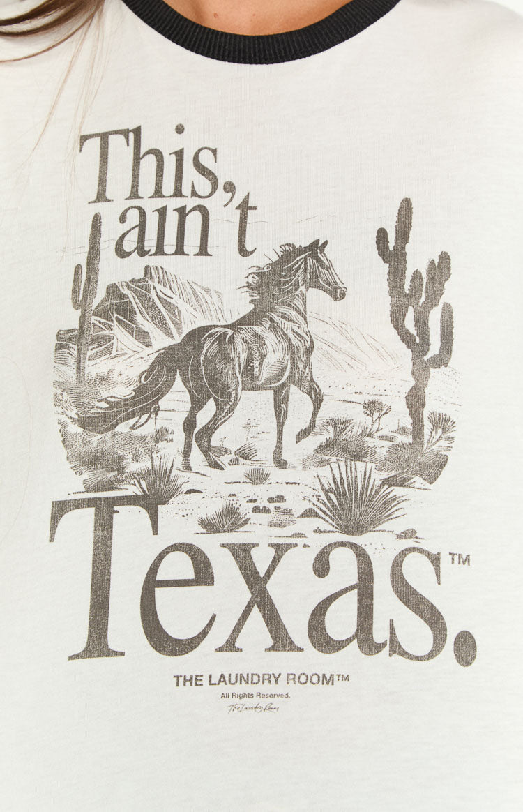 Graphic print on the white tee featuring a horse in a desert landscape with 'This, ain't Texas.' text and black ringer neckline