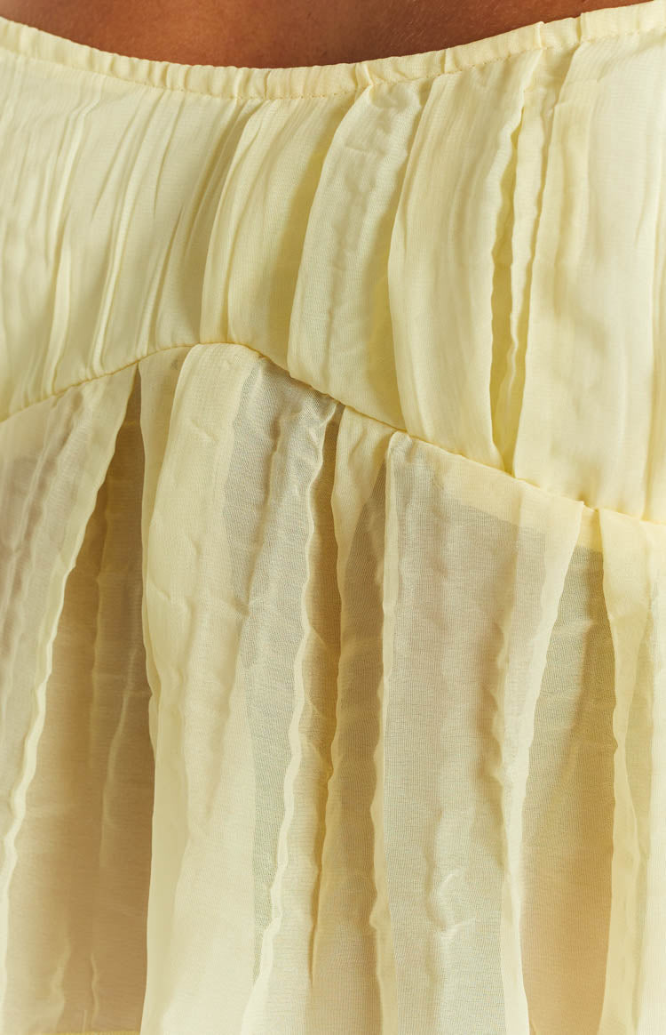 Close-up of the yellow cami top's gathered bodice seam and crinkled sheer fabric