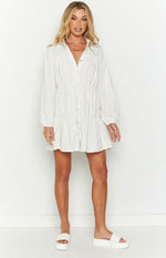White button-front mini dress with a collared V-neck, long sleeves, and gathered tiered skirt