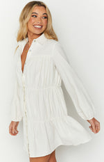 White collared button-down dress with gathered bodice, long sleeves, and tiered skirt
