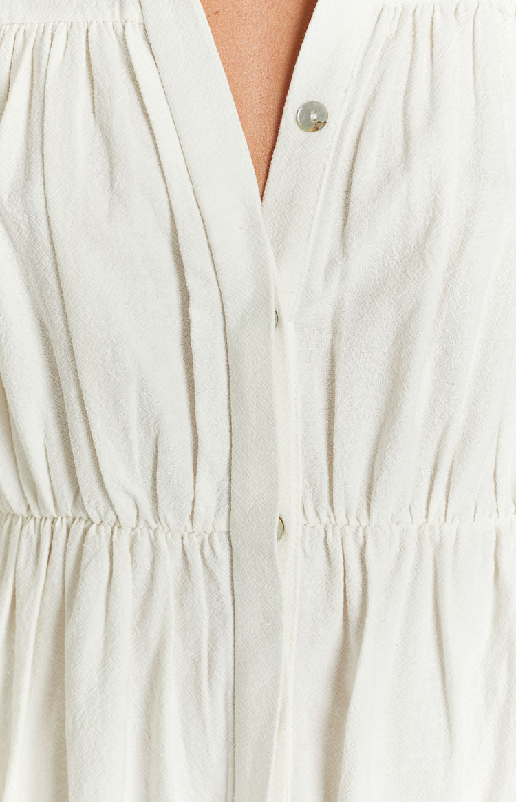 White textured dress with V-neck, button placket, and elasticated gathered waist