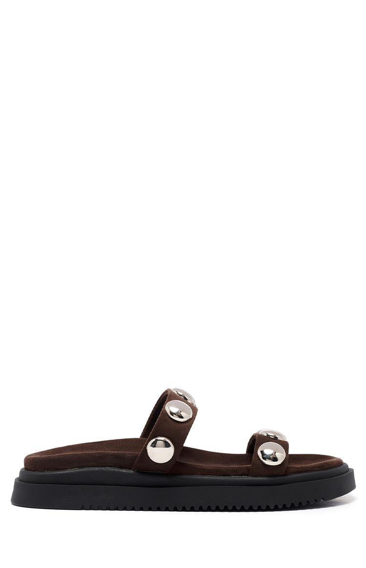 Side view of chocolate suede platform sandals with two straps adorned with large silver studs and a thick black sole