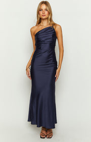 Front view of a navy one-shoulder maxi dress with a draped and ruched bodice and a smooth flowing maxi skirt