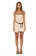 Front view of a cream mini dress with brown trim, square neckline, spaghetti straps, and a wrap tie waist